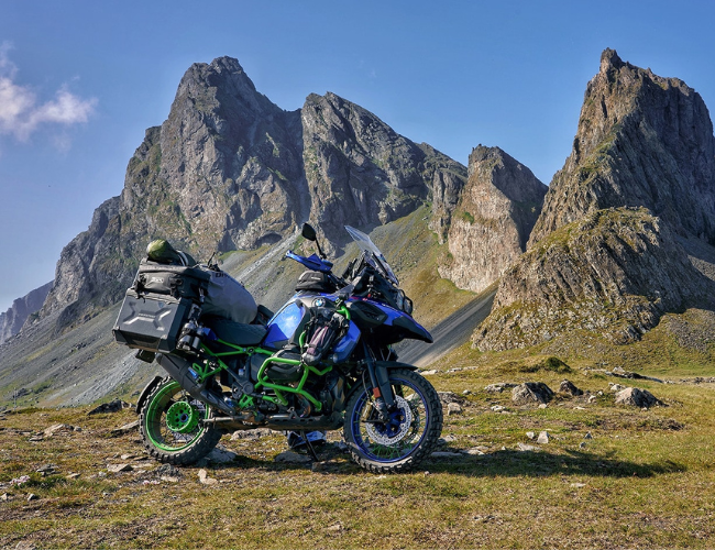 Adventure touring motorcycle with luggage setup in mountain landscape, featured by Machinehead Moto