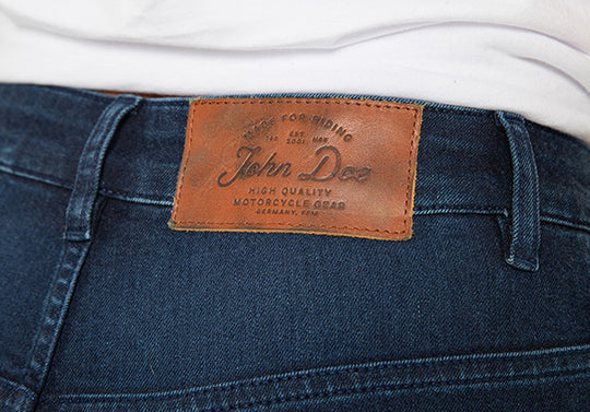 Model-Wearing-Ruby-Indigo-Mono-Layer-Jeans-Close-Up-Rear-John-Doe-Logo-Patch