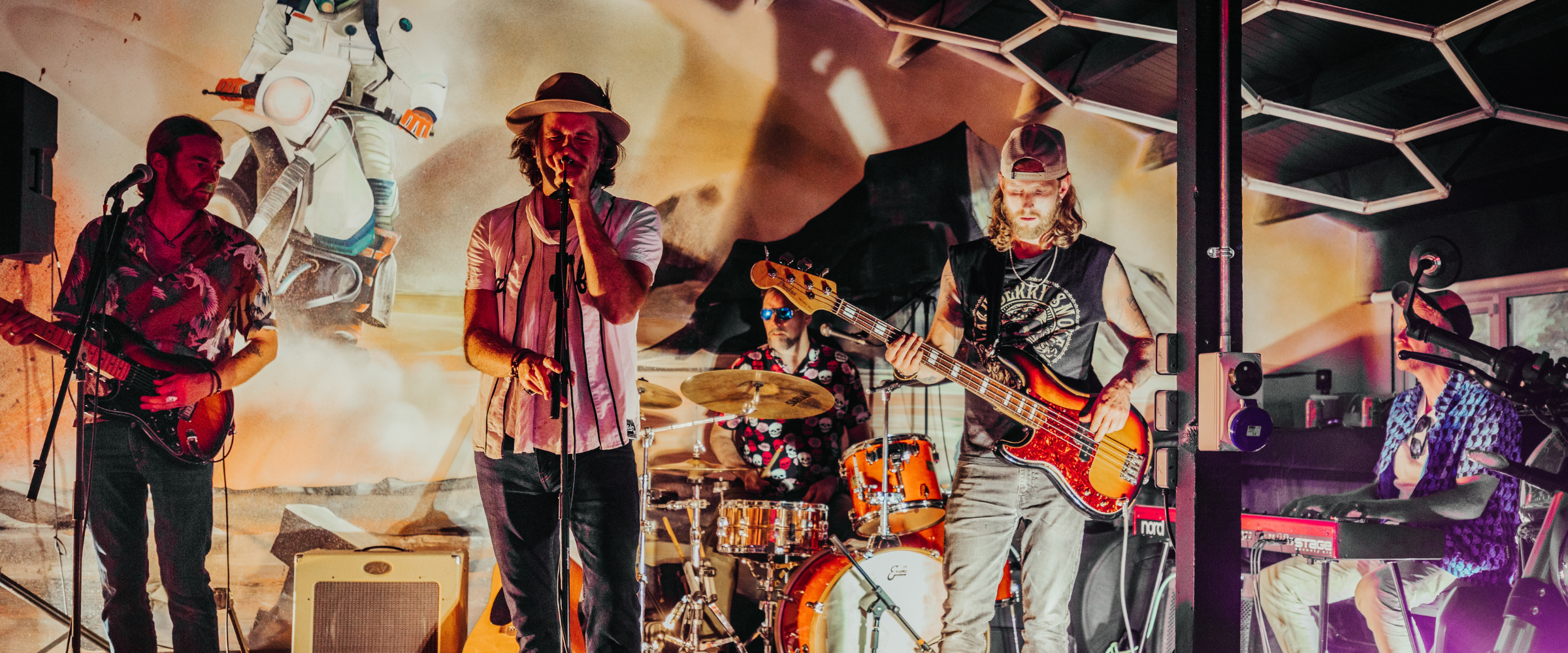 Live band playing at Machinehead Moto in front of a custom-painted motorcycle mural, capturing the energy of music, moto culture, and community connection.