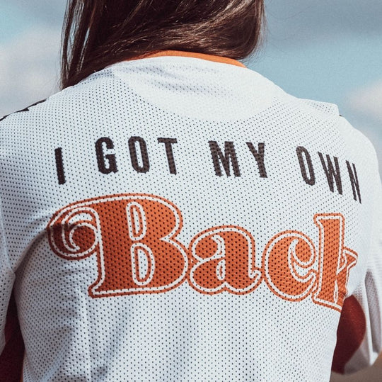 Model back view wearing Wildust Sisters Jersey Cross – Woman Racer top