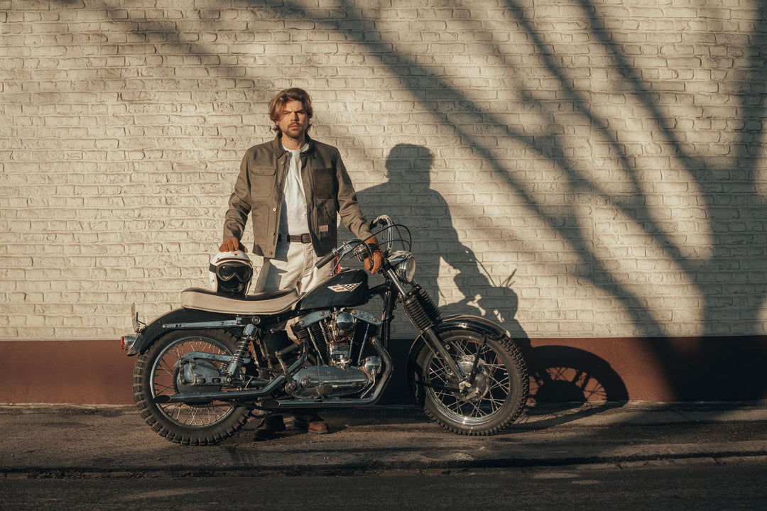 Model Wearing Age Of Glory Craftsman Jacket in Olive, Front View, with Motorcycle