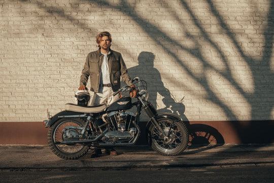 Model Wearing Age Of Glory Craftsman Jacket in Olive, Front View, with Motorcycle