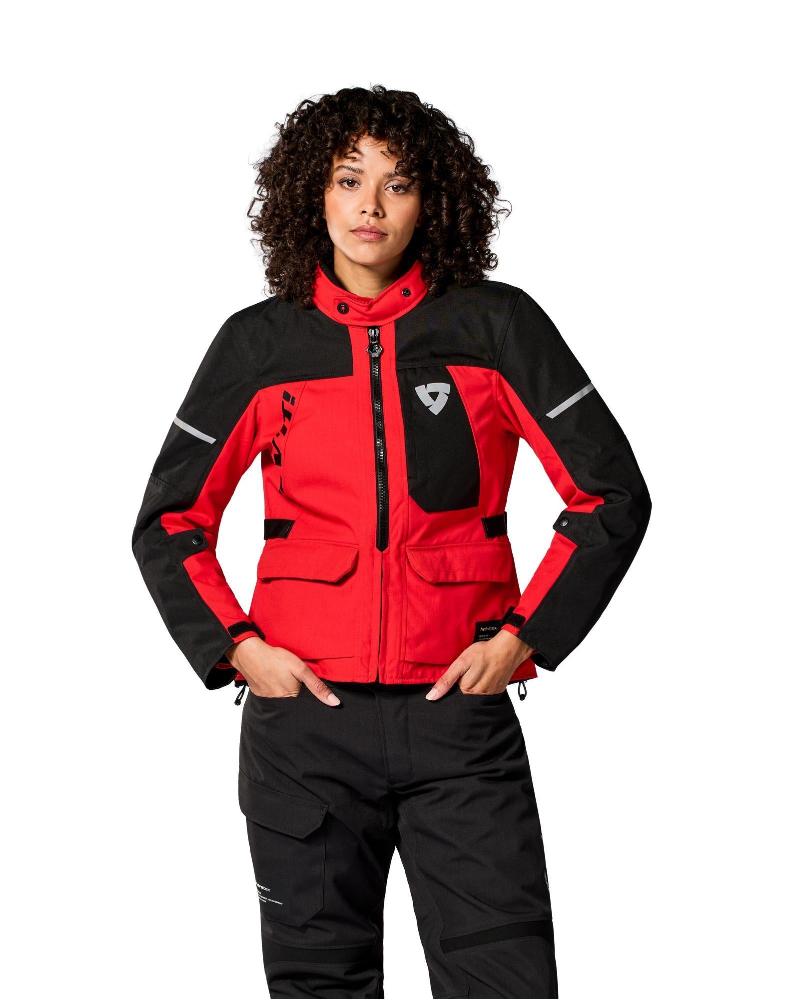 Woman wearing red and black REV'IT! Convergent H2O Ladies Adventure Motorcycle Jacket, front view
