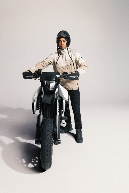 Model wearing REV’IT! Altair H2O Smock, Sand next to motorbike