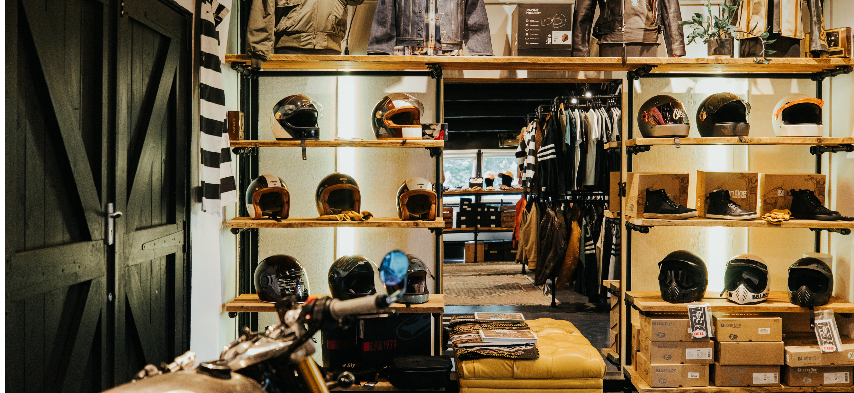 Interior of Machinehead Moto shop showing helmets, jackets, and custom motorcycle gear next to the workshop
