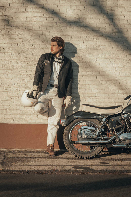 Model Wearing Age of Glory Runaway Riding Shirt in Black – Front View, Jacket open Cord Collar and Buttons with Zip next to motorcycle