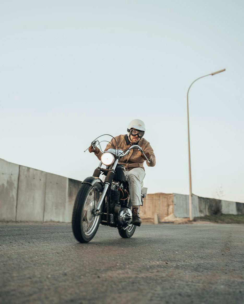 Age of Glory Runaway Riding Shirt in Desert Khaki – Rider on Motorcycle, Front View Holding Handle Bars
