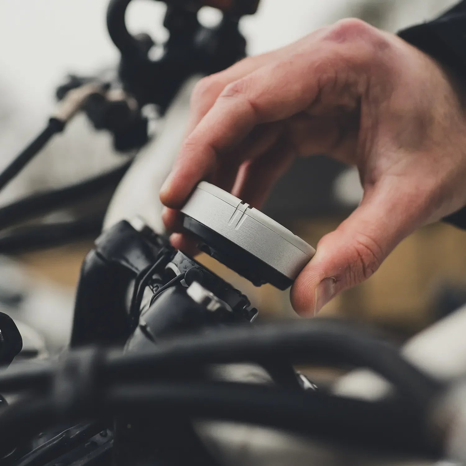 Beeline Moto II being attached to motorcycle handlebars using quick-release twist-lock mount