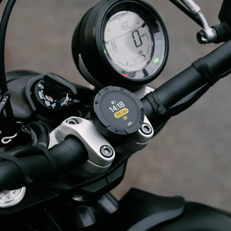 Beeline Moto II mounted on motorcycle handlebars showing ride data screen with time and distance