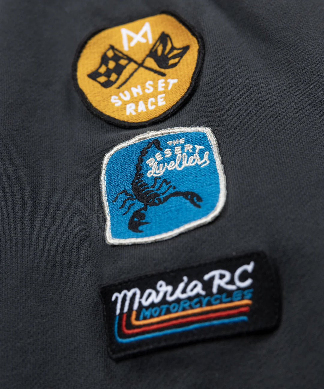 maria-riding-hoodie-desert-dwellers-front-race-patches-close-up