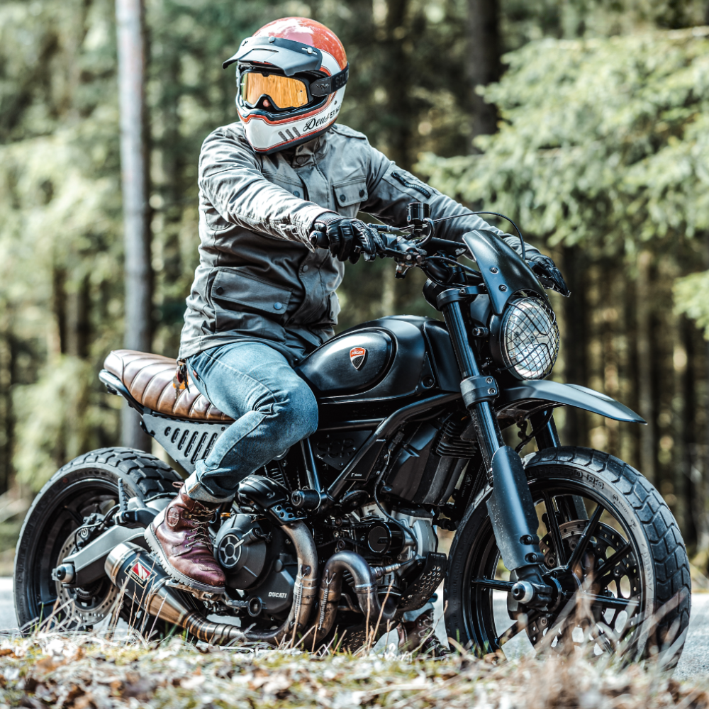 Rider-Wearing-John-Doe-Explorere-Jacket-Helmet-Orange-Mirrored-Goggles-Scrambler-Motorcycle-Woodland-Caged-Headlight