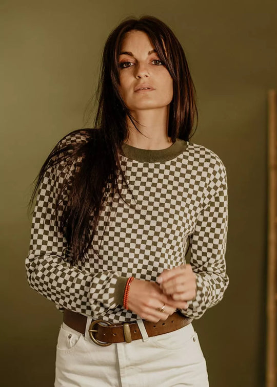 Model wearing the Wildust Sisters Vintage Racing Jumper in Khaki with a classic chequered knit design
