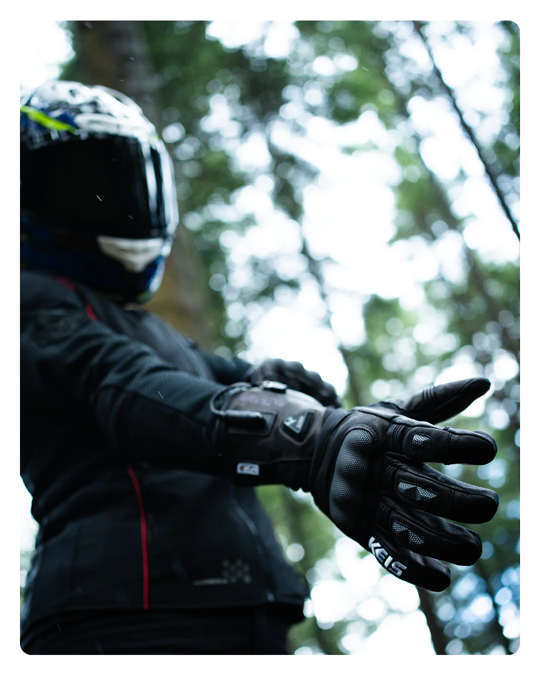 Motorcyclist wearing Keis G901 Extreme Heated Gloves in woodland setting.