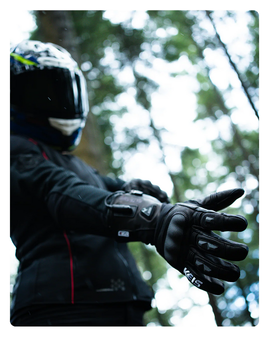 Motorcyclist wearing Keis G901 Extreme Heated Gloves in woodland setting.