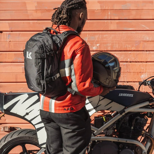 Rider wearing Kriega Backpack R20 in black next to motorcycle shed