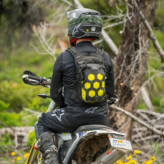 Rider wearing Kriega Trail 9 lime motorcycle backpack on KTM adventure bike