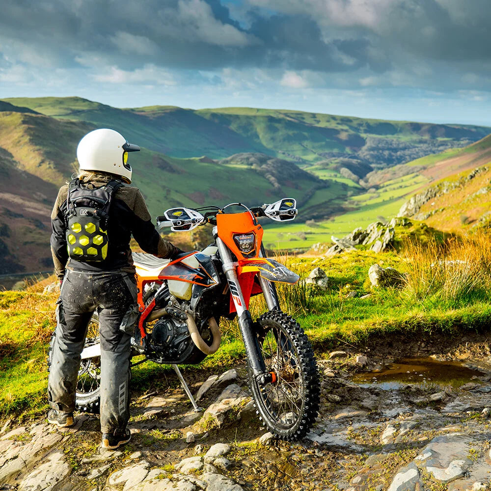 Rider wearing Kriega Trail 9 lime motorcycle backpack off road with enduro bike
