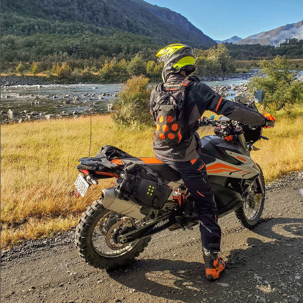 Rider wearing Kriega Trail 9 orange motorcycle backpack on KTM adventure bike