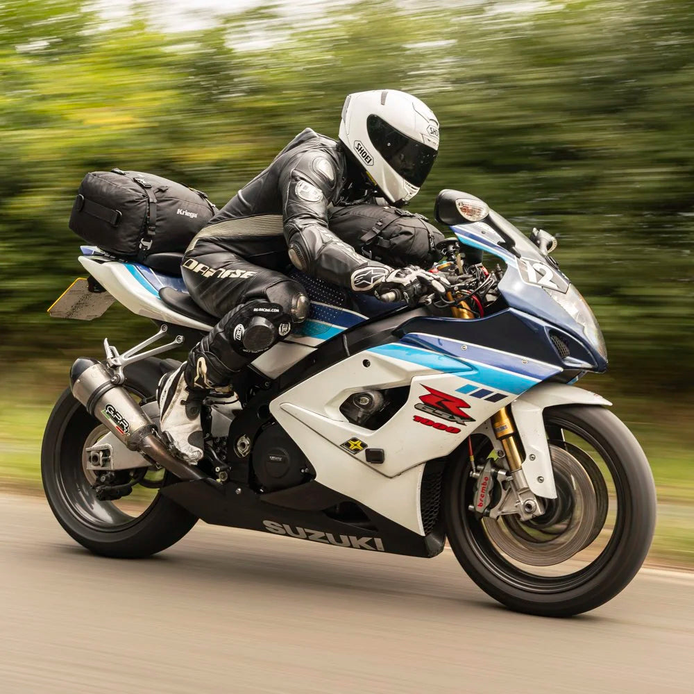 Suzuki sportbike rider carrying Kriega US-20 and US-10 Drypack motorcycle luggage while riding at speed