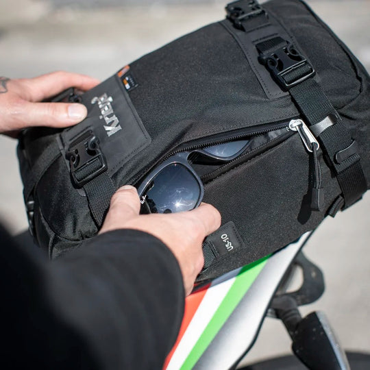 Kriega US-10 Drypack side zip pocket with sunglasses being stored on motorcycle