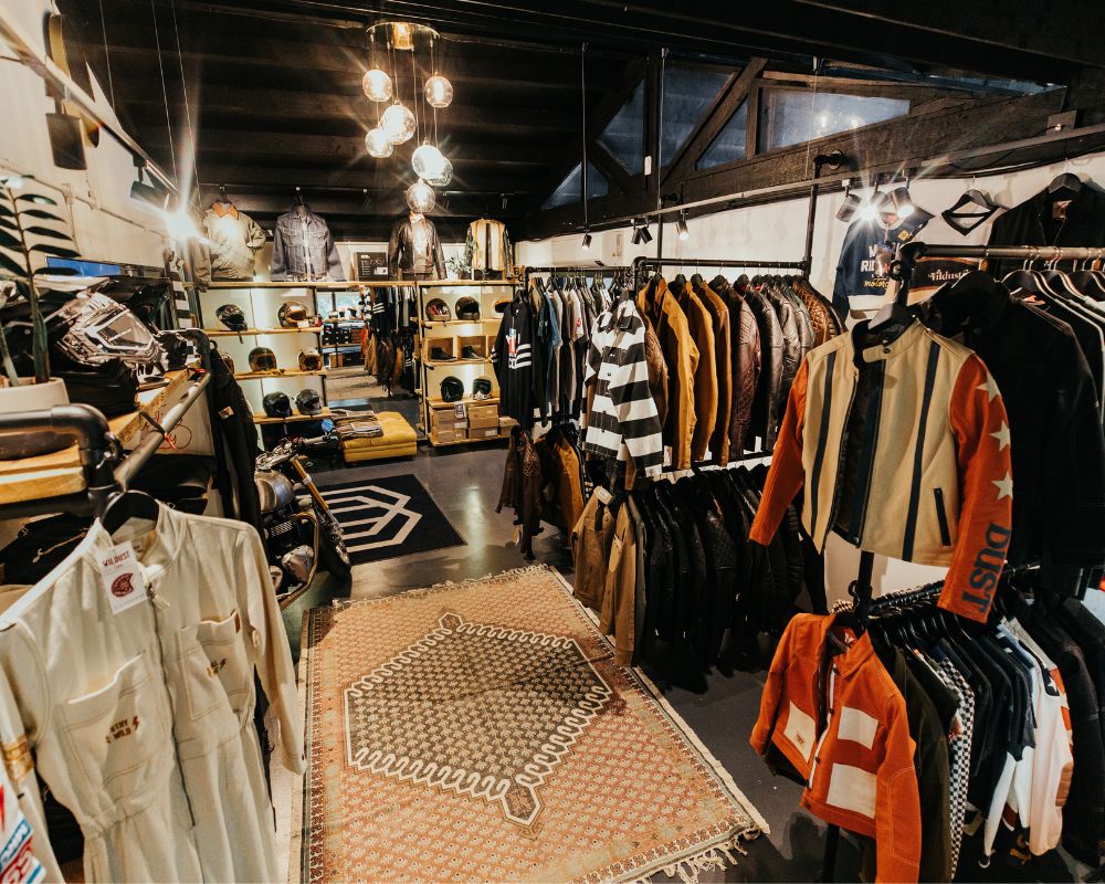 Interior of Machinehead Moto store showing motorcycle jackets, boots, trousers, helmets, and riding gear on display