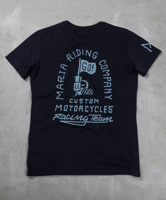 Black t-shirt with white graphic design on a gray concrete surface