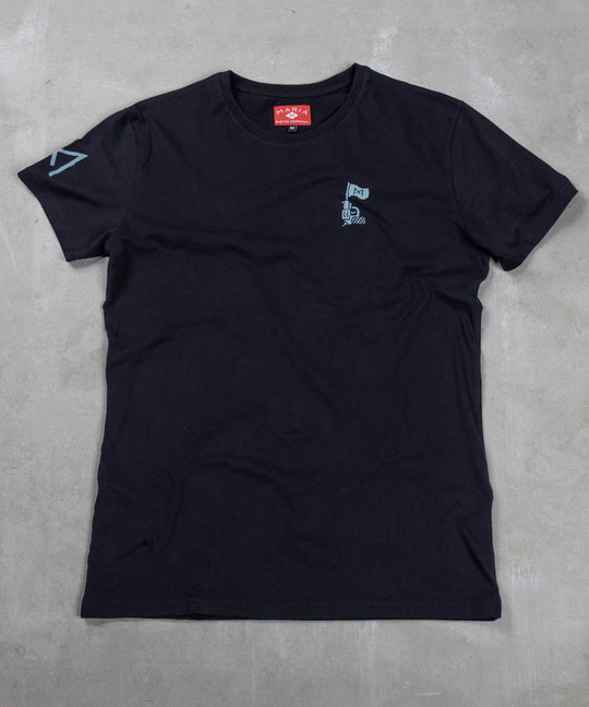 Black t-shirt with small logo on a gray concrete surface