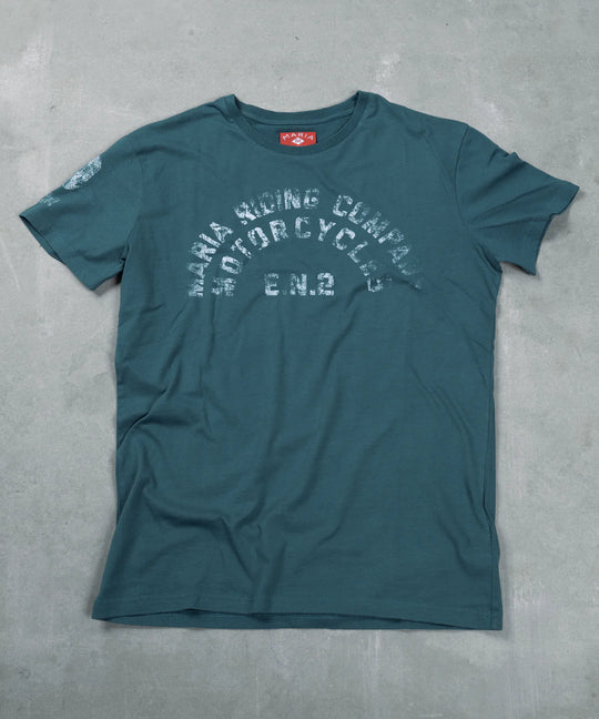 Teal t-shirt with text on a gray surface