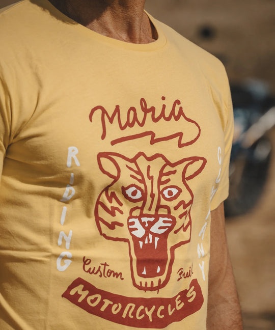 Yellow t-shirt with a red graphic of a tiger and text on a blurred background