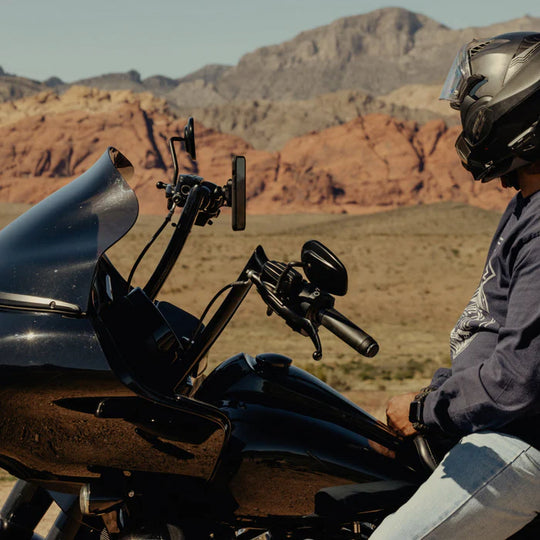 Peak Design brake and clutch motorcycle phone mount installed on handlebar in desert landscape