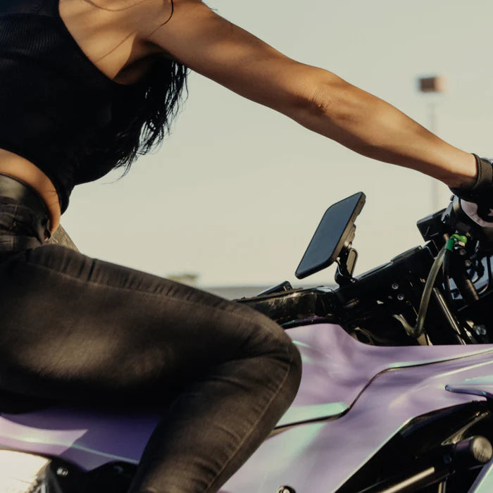 Woman riding motorcycle with Peak Design stem mount charging head attached