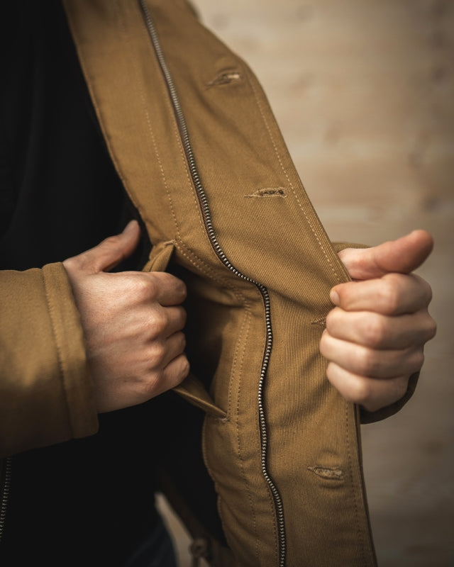 Man Opening the Pike Brothers 1943 N1 Deck Jacket in Desert Tobacco Brown Showing the Inner Placket