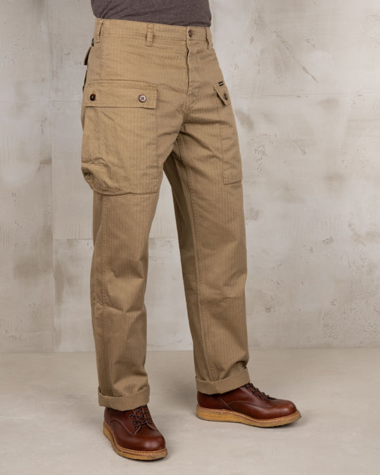 3/4 view of male model wearing Pike Brothers 1944 Monkey Pant in Olive