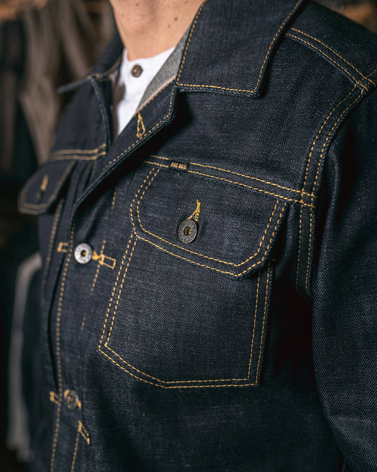 Close-up of left chest pocket on Pike Brothers 1958 Roamer Jacket showing button detail and contrast yellow stitching