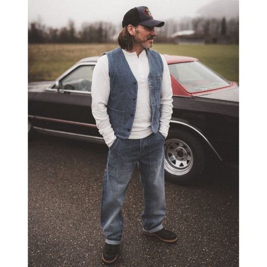 Pike Brothers 1967 utility trousers blue lifestyle image worn with matching vest beside classic car