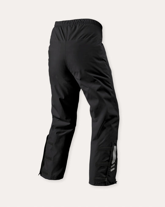 REV’IT! black waterproof motorcycle overpants rear view with elastic waist and adjustable lower leg closures