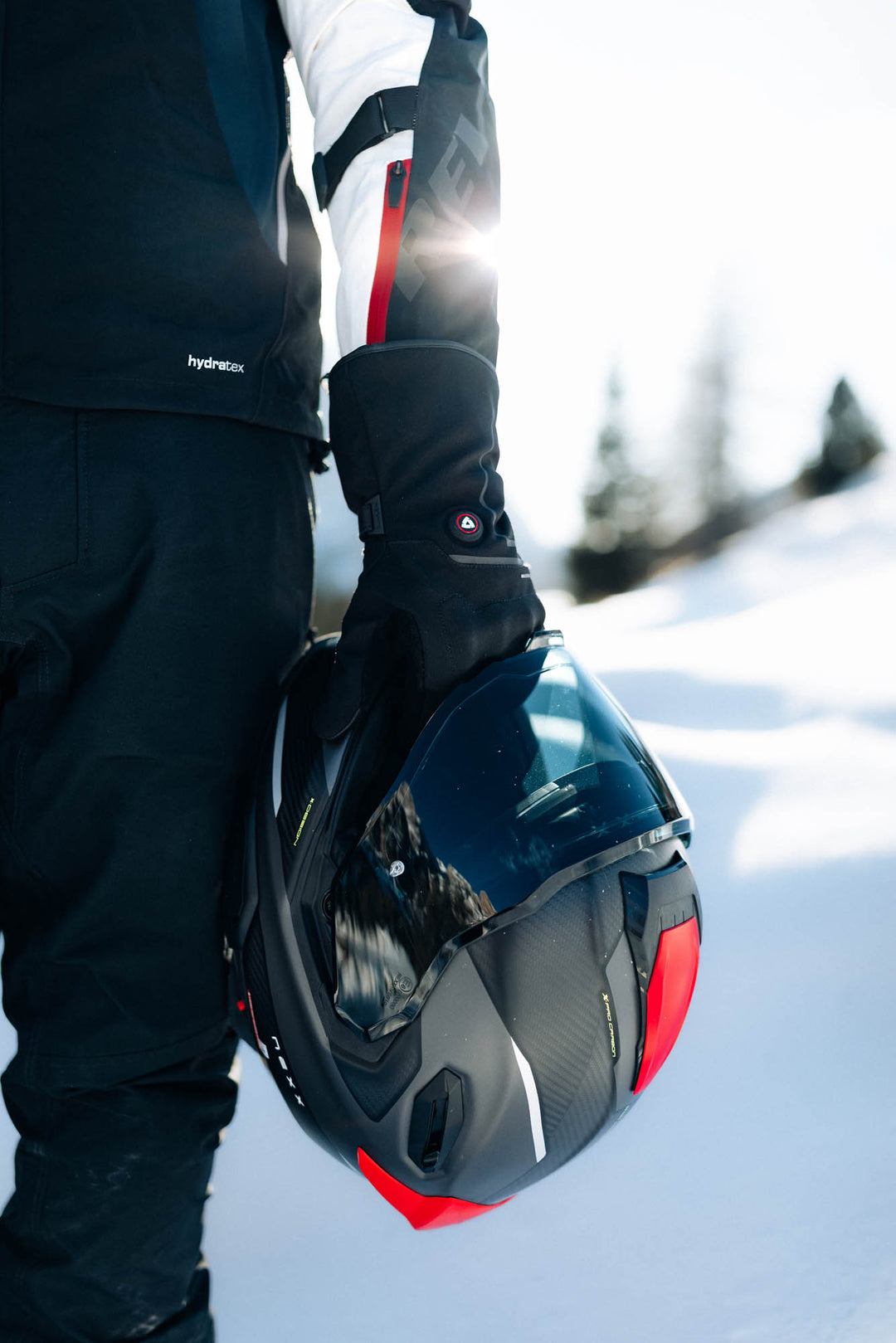 REV’IT! Freedom H2O Heated Gloves worn by rider holding helmet.
