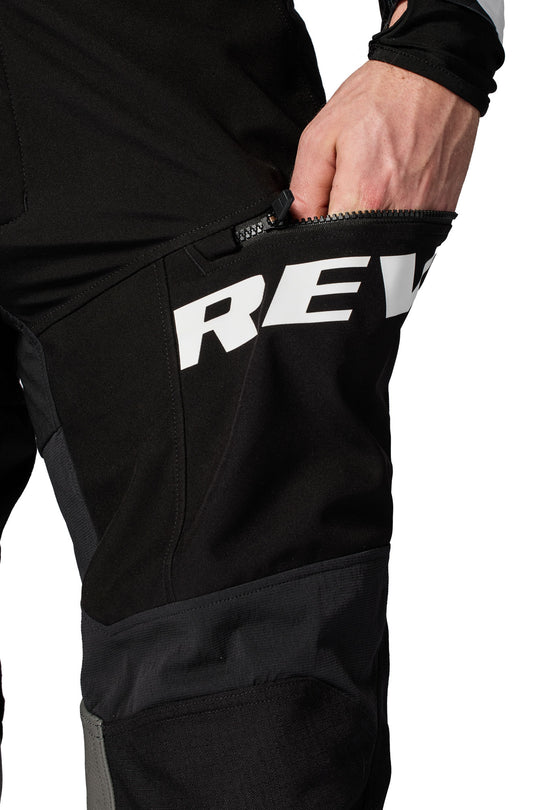 REV’IT! Lejano Motorcycle Trousers in black, close-up zippered thigh pocket detail.
