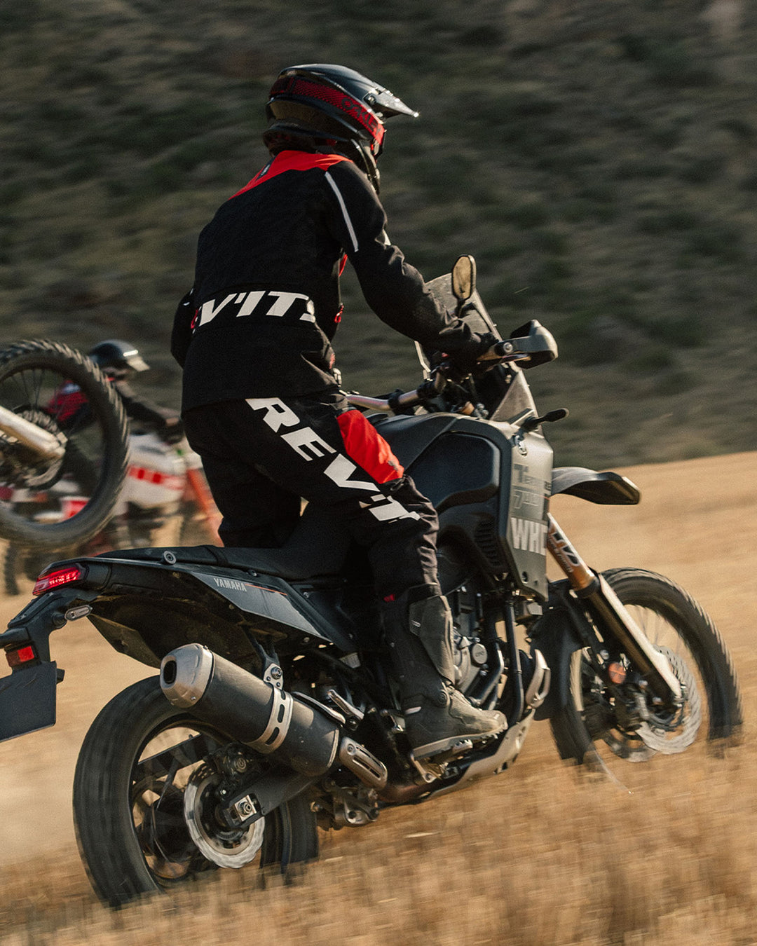 Model wearing REV’IT! Lejano Motorcycle Trousers while riding an adventure motorcycle off-road.
