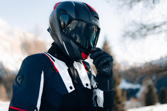 Model wearing REV’IT! Liberty 2 H2O Men’s Heated Motorcycle Gloves in black in snowy conditions.
