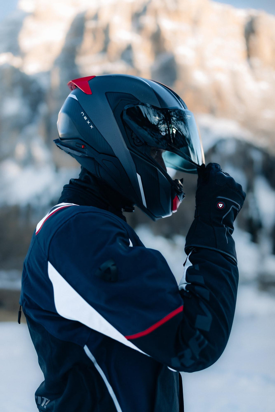Model wearing REV’IT! Liberty 2 H2O Men’s Heated Motorcycle Gloves in black in snowy conditions.
