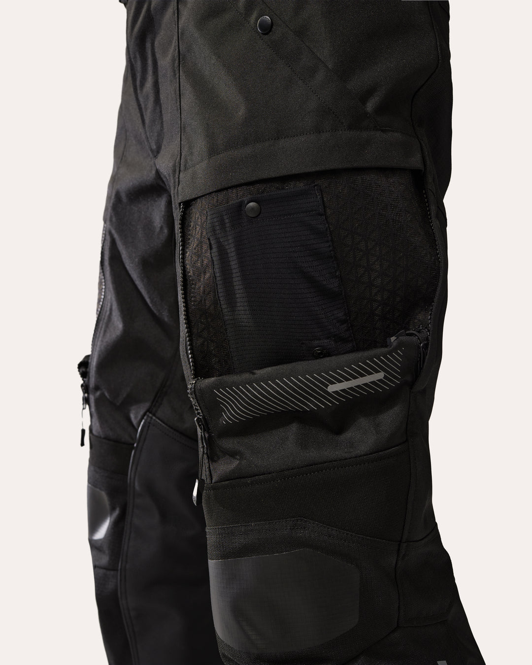 REV'IT! Sand 5 H2O black motorcycle trousers close-up – thigh ventilation panel open showing mesh lining