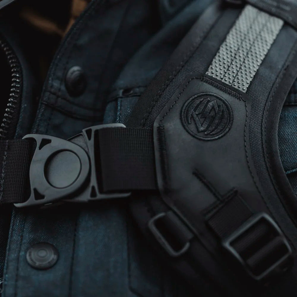 Close-up of Roland Sands Design x Kriega Roam 34 Backpack harness buckle with logo detail