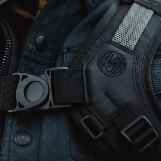 Close-up of Roland Sands Design x Kriega Roam 34 Backpack harness buckle with logo detail