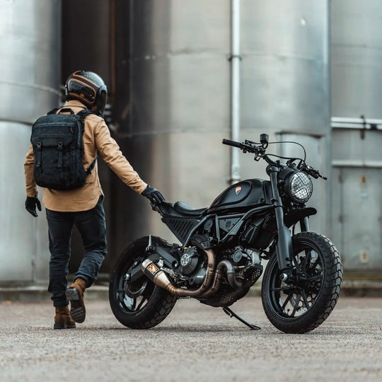 Rider wearing Roland Sands Design x Kriega Roam 34 Backpack in brown on black motorcycle in city street