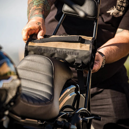 Roland Sands Design x Kriega Roam Tool Roll Ranger in brown mounted on motorcycle sissy bar outdoors