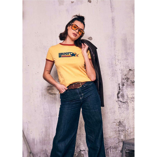 Wildust Sisters Racing T-shirt in yellow starburst logo graphic mid body lifestyle worn view
