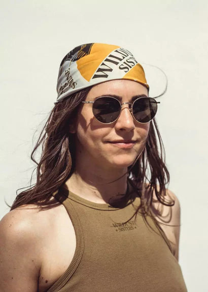 Wildust Sisters Ride & Shine Scarf worn as headband – khaki, ecru and orange print