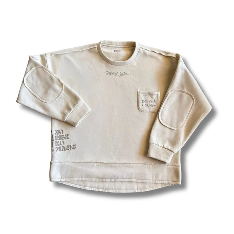 Wildust Sisters Escape Sweatshirt in ecru with external seams, elbow patches, front pocket and sleeve text on white background.