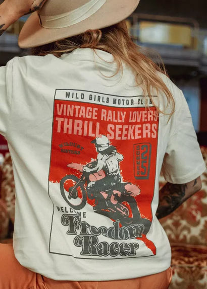 Model wearing Wildust Sisters Freedom Racer T-shirt showing large vintage rally back graphic.